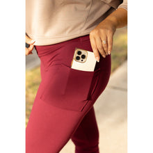 Load image into Gallery viewer, High-waisted maroon crossover leggings with pockets by Julia Rose, Julia Rose women’s maroon full length leggings lifestyle image