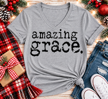 Load image into Gallery viewer, A heather gray V-neck t-shirt with the words 'amazing grace.' printed in a distressed black typewriter font.