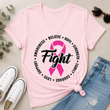 Load image into Gallery viewer, A light pink V-neck T-shirt laid flat on a light beige surface, styled with white sneakers, blue jeans, sunglasses, and eucalyptus leaves. The shirt has a large black and pink graphic on the front featuring a ribbon and the word 'Fight' surrounded by supportive words.