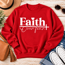 Load image into Gallery viewer, Faith Over Fear Christian inspirational graphic apparel featuring bold white Faith lettering, elegant Over Fear script, a small heart, and a cross design. Available in red and black in short sleeve crewneck, long sleeve crewneck, crewneck sweatshirt, and hoodie styles. Faith-based graphic clothing for women, everyday wear, church outfits, and inspirational gifts.