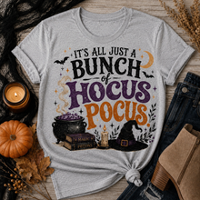 Load image into Gallery viewer, Gray Halloween graphic tee with It’s All Just a Bunch of Hocus Pocus lettering, cauldron, spell books, witch hat and bats.