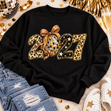 Load image into Gallery viewer, Black 2027 New Year's graphic apparel featuring leopard print numbers, a gold disco ball with an oversized glittery bow, black and gold stars, and sparkling accents. Available in crewneck tee, V-neck tee, sweatshirt, and hoodie styles.