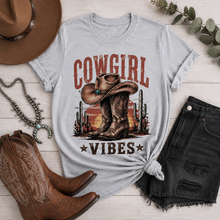 Load image into Gallery viewer, Cowgirl Vibes western graphic apparel featuring cowboy boots, cowgirl hat, cacti and desert sunset design
