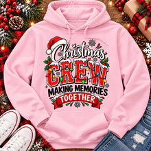 Load image into Gallery viewer, Christmas Crew Making Memories Together graphic on a pink crewneck T-shirt, featuring red lettering, colorful Christmas lights, a Santa hat, holly, and snowflakes.
