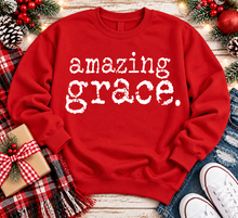 Load image into Gallery viewer, A red crewneck sweatshirt with the words 'amazing grace.' printed in a distressed white typewriter font across the chest.
