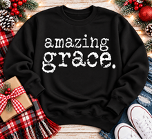 Load image into Gallery viewer, A black crewneck sweatshirt with the words 'amazing grace.' printed in a distressed white typewriter font across the chest.
