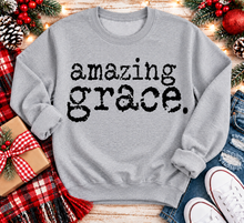 Load image into Gallery viewer, A light gray crewneck sweatshirt with the words 'amazing grace.' printed in a black distressed typewriter font.
