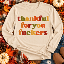 Load image into Gallery viewer, Funny Thankful for You Fuckers Thanksgiving graphic tee featuring bold retro lettering in burnt orange, mustard yellow, olive green, and rust red. Women's fall-inspired short sleeve crewneck shirt available in beige and brown, perfect for Thanksgiving and Friendsgiving.
