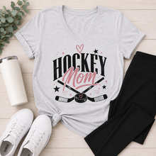 Load image into Gallery viewer, Heather gray v-neck Hockey Mom graphic tee featuring a black and pink hockey design styled with black leggings and white sneakers.
