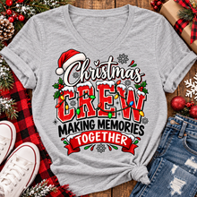 Load image into Gallery viewer, Christmas Crew Making Memories Together graphic on a pink crewneck T-shirt, featuring red lettering, colorful Christmas lights, a Santa hat, holly, and snowflakes.
