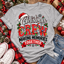 Load image into Gallery viewer, Christmas Crew Making Memories Together graphic on a pink crewneck T-shirt, featuring red lettering, colorful Christmas lights, a Santa hat, holly, and snowflakes.
