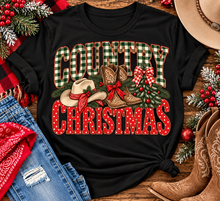 Load image into Gallery viewer, Country Christmas graphic tee with green plaid lettering, red polka dots, cowboy boots, western hat and festive Christmas bows.

