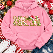 Load image into Gallery viewer, Christmas MAMA graphic shirt featuring pink and green patterned lettering, colorful holiday lights, and a Grinch-inspired character wearing a Santa hat.
