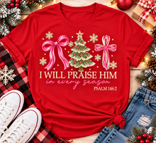 Load image into Gallery viewer, Christian Christmas shirt featuring I Will Praise Him in Every Season Psalm 146:2 graphic with pink bows, decorated Christmas tree, and cream snowflakes.
