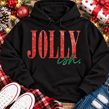 Load image into Gallery viewer, Jolly Ish Christmas graphic shirt featuring large distressed red JOLLY lettering with green handwritten ish script. Funny vintage-inspired holiday apparel available in pink and black, offered in short sleeve crewneck, V-neck, long sleeve and hoodie styles.
