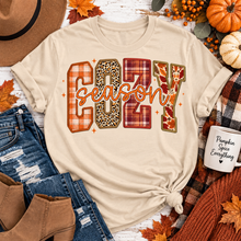 Load image into Gallery viewer, Cream crewneck Cozy Season fall graphic tee with plaid, leopard and autumn print lettering
