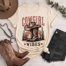 Load image into Gallery viewer, Cowgirl Vibes western graphic apparel featuring cowboy boots, cowgirl hat, cacti and desert sunset design
